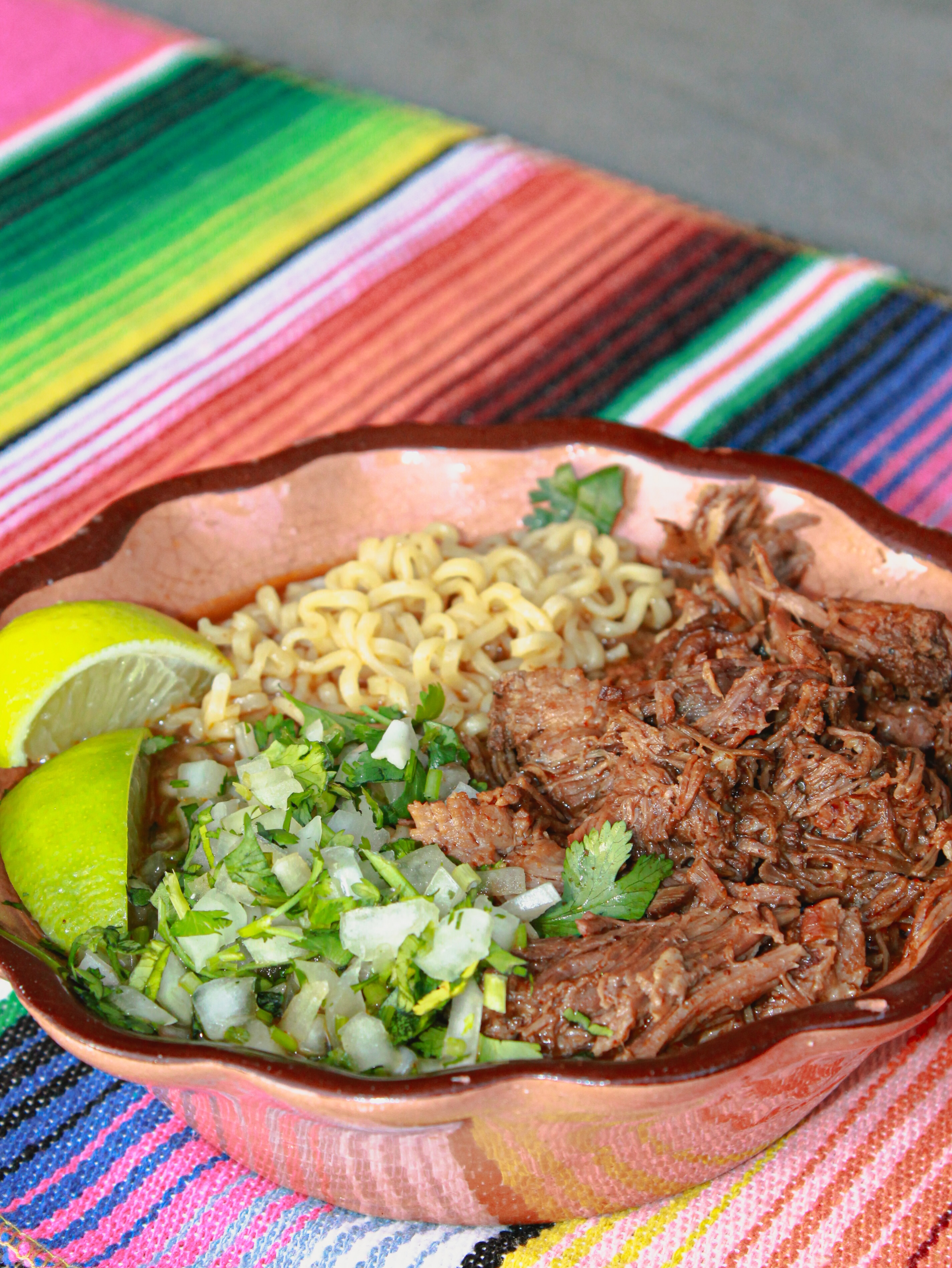 Chef Tastebudz birria ramen with fresh lime and cilantro